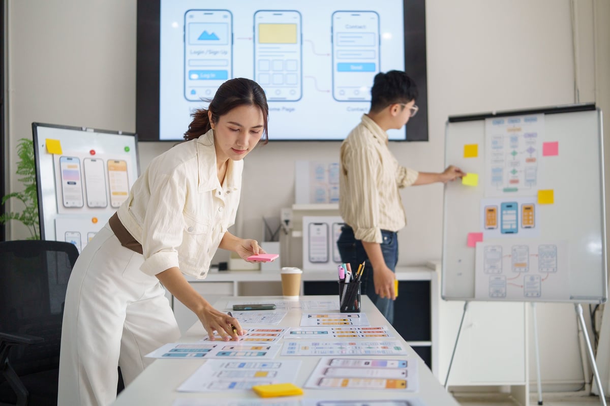 Designer mapping out a page structure and user flow with sticky notes